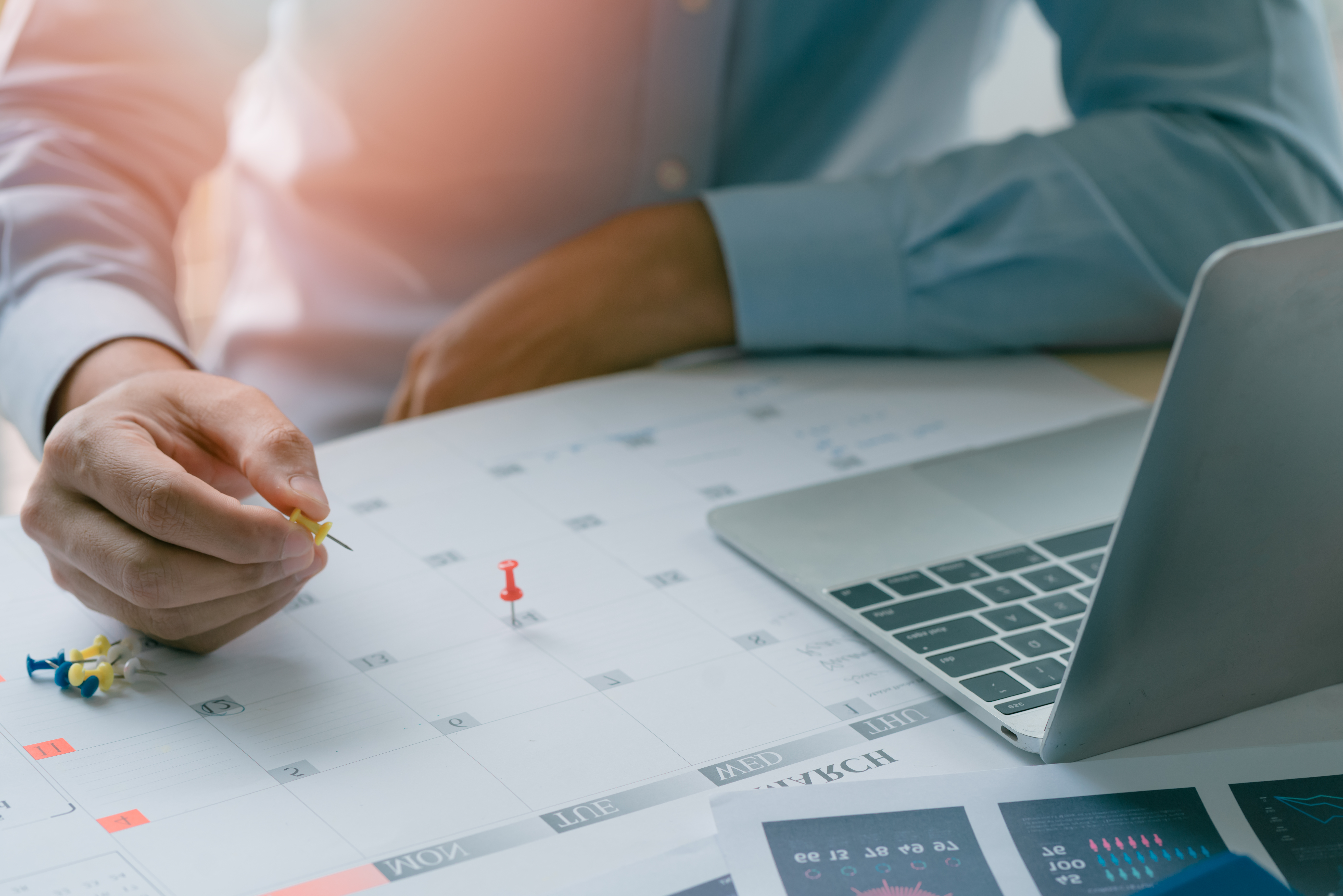 Business professional planning a schedule on a calendar.