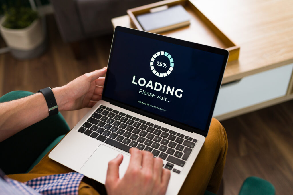 A man working on a laptop with a loading screen displayed